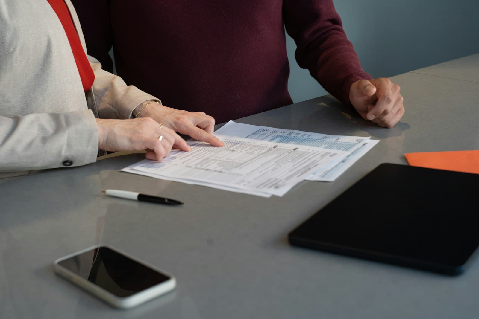 Two people reviewing printed documents together at a table